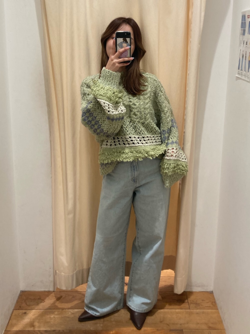 グリーン系のニット/セーター、ブルー系のデニムパンツ、ブラウン系のブーツを着用したレディースの冬コーディネートの1枚目の写真