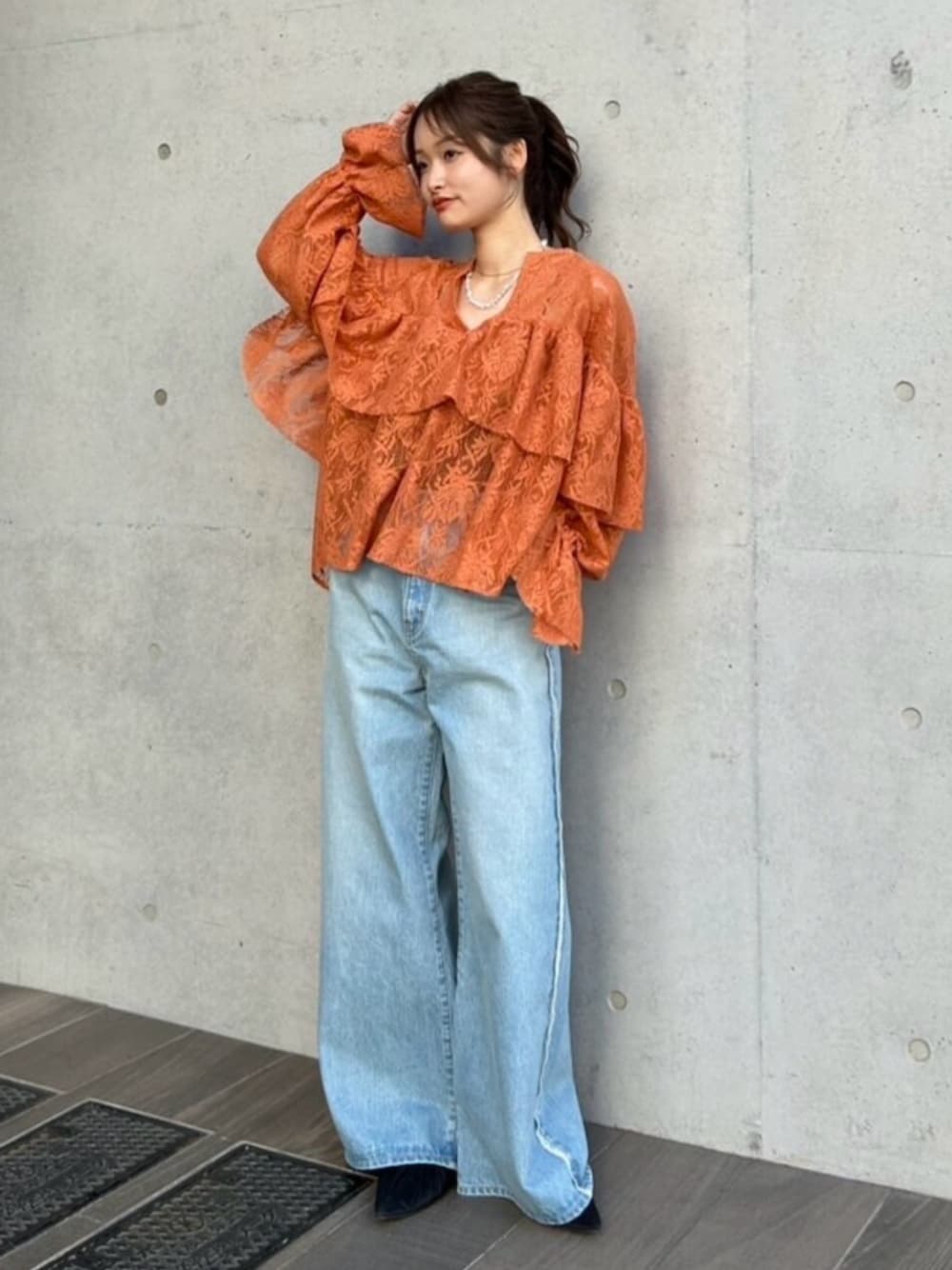 ブルー系のデニムパンツ、ブラック系のパンプス、オレンジ系のシャツ/ブラウスを着用したレディースの冬コーディネートの1枚目の写真