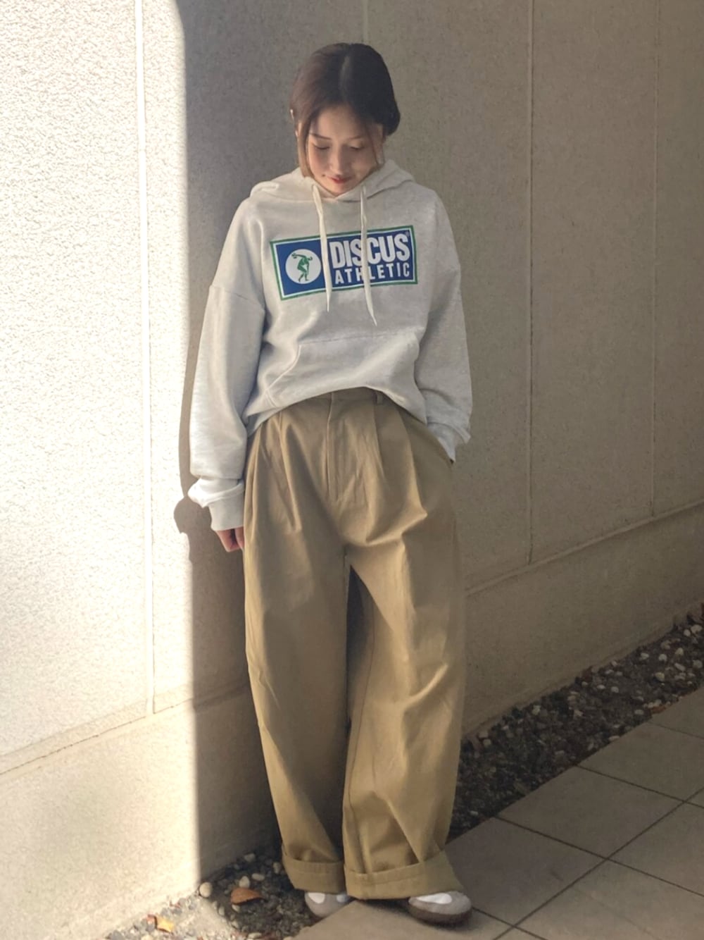 ベージュ系のチノパンツ、グレー系のパーカーを着用したレディースの冬コーディネートの1枚目の写真