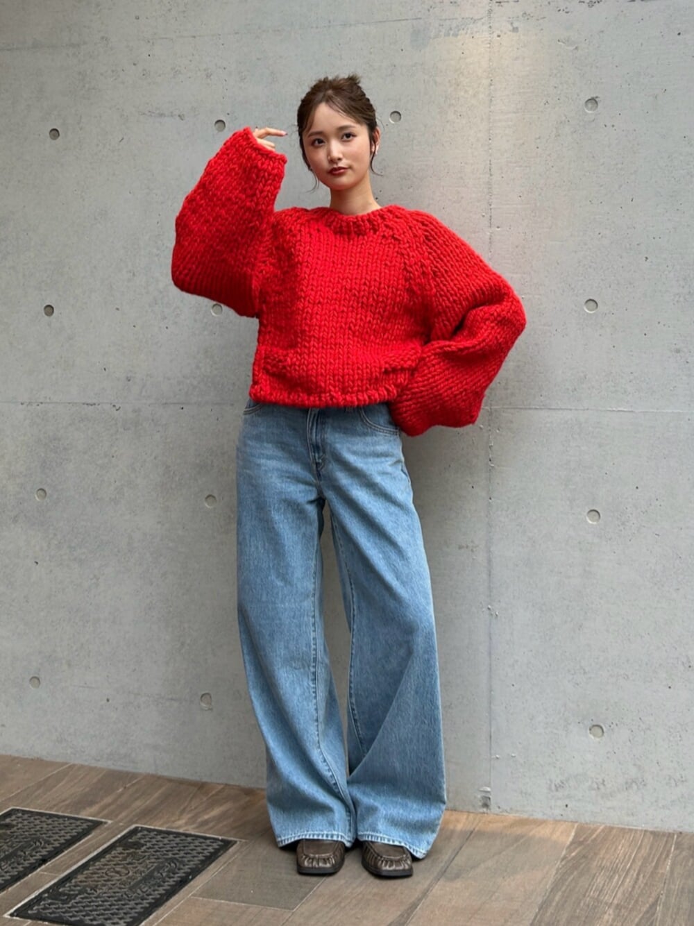 ブルー系のデニムパンツ、レッド系のニット/セーターを着用したレディースの秋コーディネートの1枚目の写真