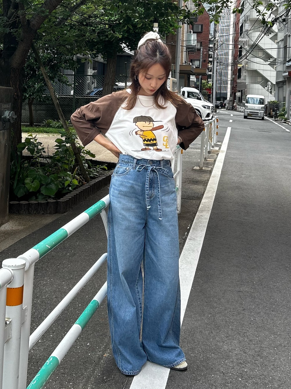 ブルー系のデニムパンツ、ベージュ系のローファー、ブラウン系のTシャツ/カットソーを着用したレディースの夏コーディネートの1枚目の写真