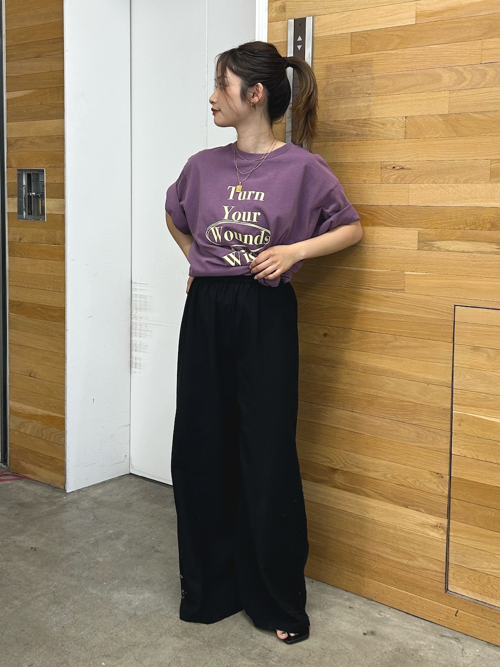 パープル系のTシャツ/カットソー、ブラック系のその他パンツ、ブラック系のサンダルを着用したレディースの春コーディネートの1枚目の写真