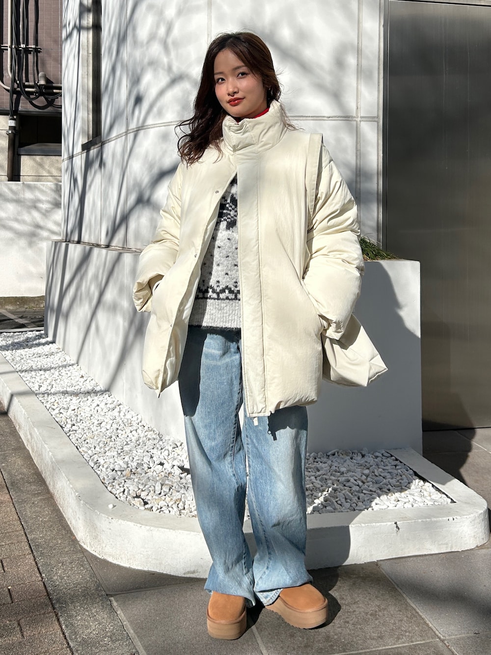 グレー系のニット/セーター、ブルー系のデニムパンツ、レッド系のニット/セーターを着用したレディースの冬コーディネートの1枚目の写真