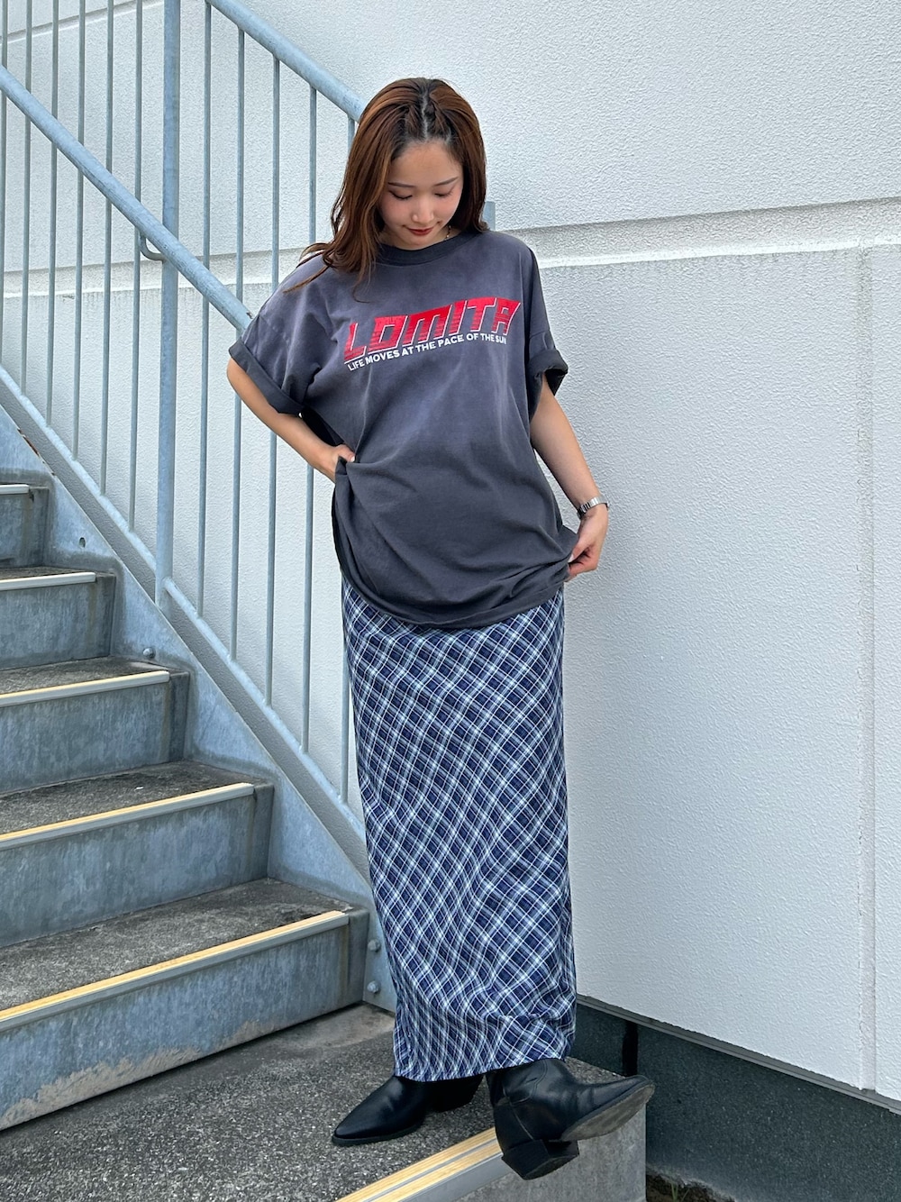 グレー系のTシャツ/カットソー、ブルー系のスカート、ブラック系のブーツを着用したレディースの春コーディネートの1枚目の写真