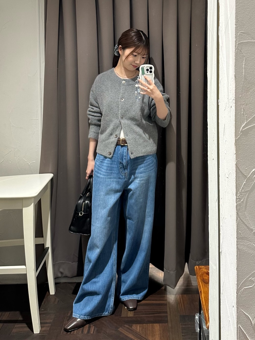 ブルー系のデニムパンツ、グレー系のカーディガン/ボレロ、ブラック系のボストンバッグを着用したレディースの秋コーディネートの1枚目の写真