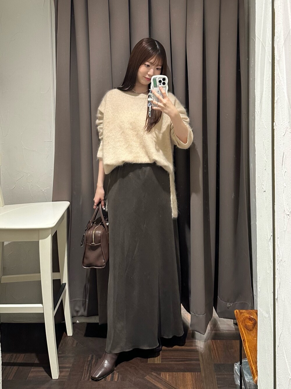 ブラウン系のスカート、ベージュ系のニット/セーター、ブラウン系のブーツを着用したレディースの秋コーディネートの1枚目の写真