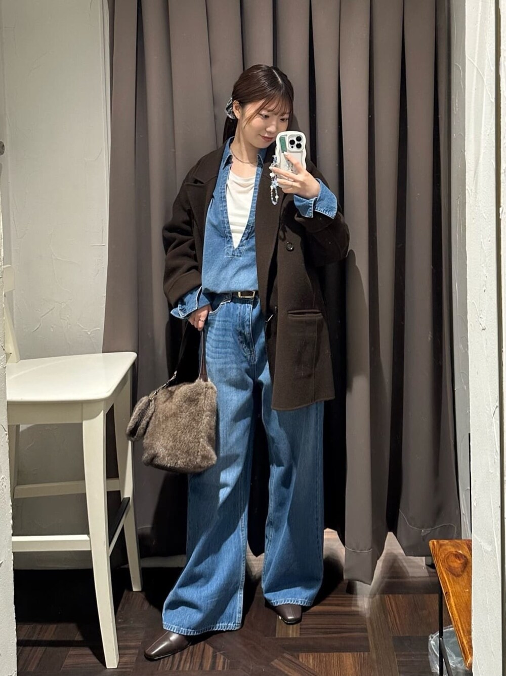 ブルー系のデニムパンツ、ブルー系のシャツ/ブラウス、ブラウン系のハンドバッグを着用したレディースの秋コーディネートの1枚目の写真