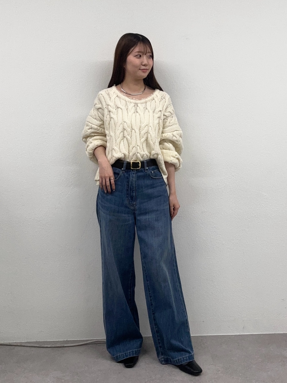 ブルー系のデニムパンツ、ホワイト系のニット/セーター、ブラウン系のブーツを着用したレディースの秋コーディネートの1枚目の写真
