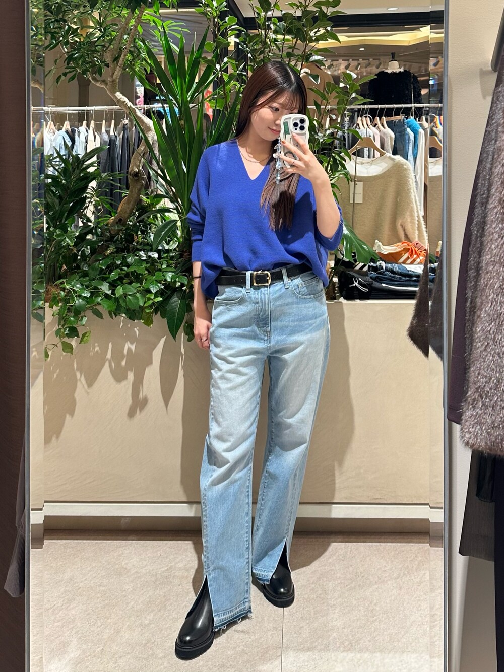 ブルー系のニット/セーター、ブルー系のデニムパンツ、ブラック系のブーツを着用したレディースの冬コーディネートの1枚目の写真