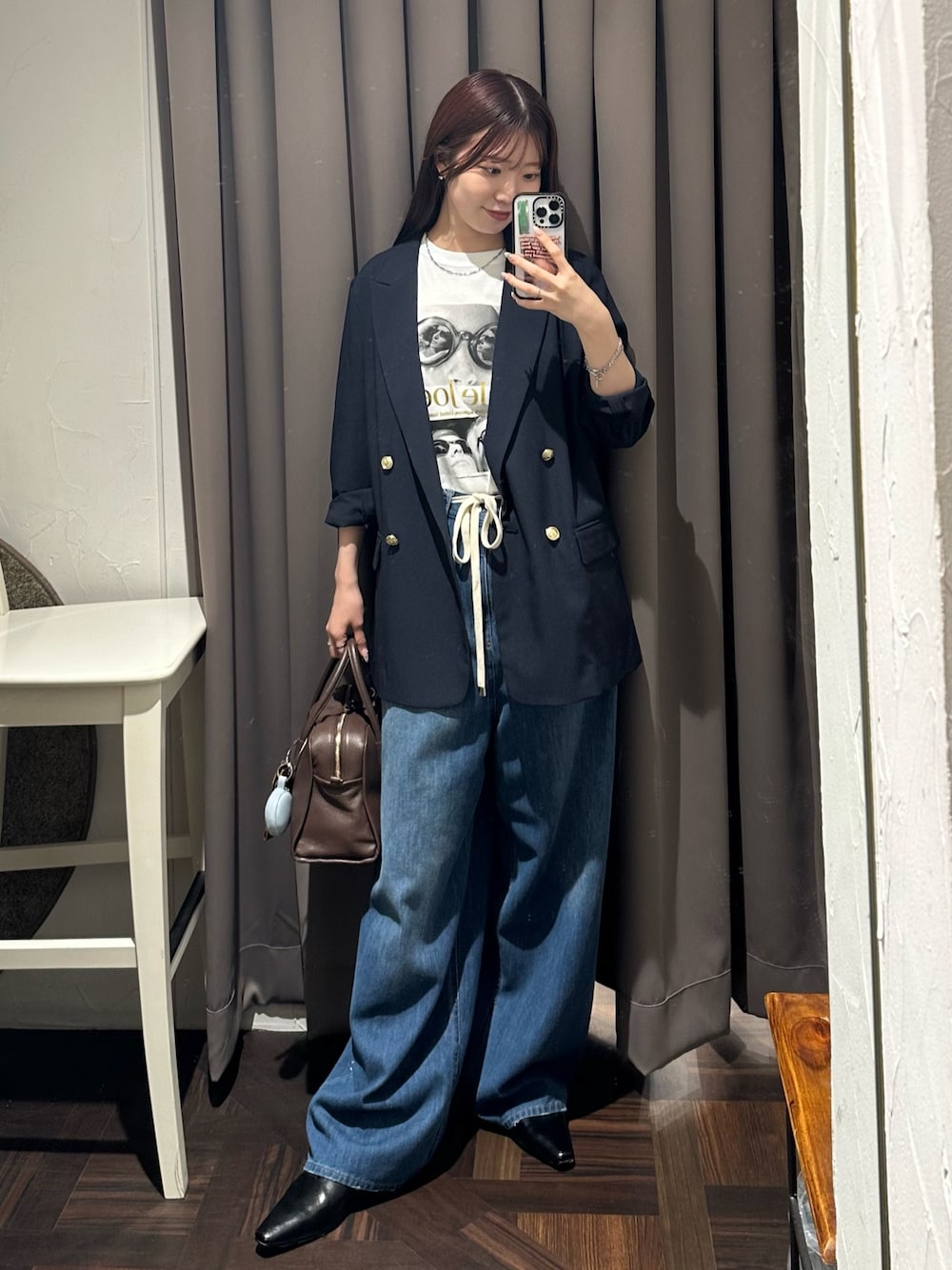 ブルー系のデニムパンツ、ブルー系のテーラードジャケット、ブラウン系のボストンバッグを着用したレディースの夏コーディネートの1枚目の写真