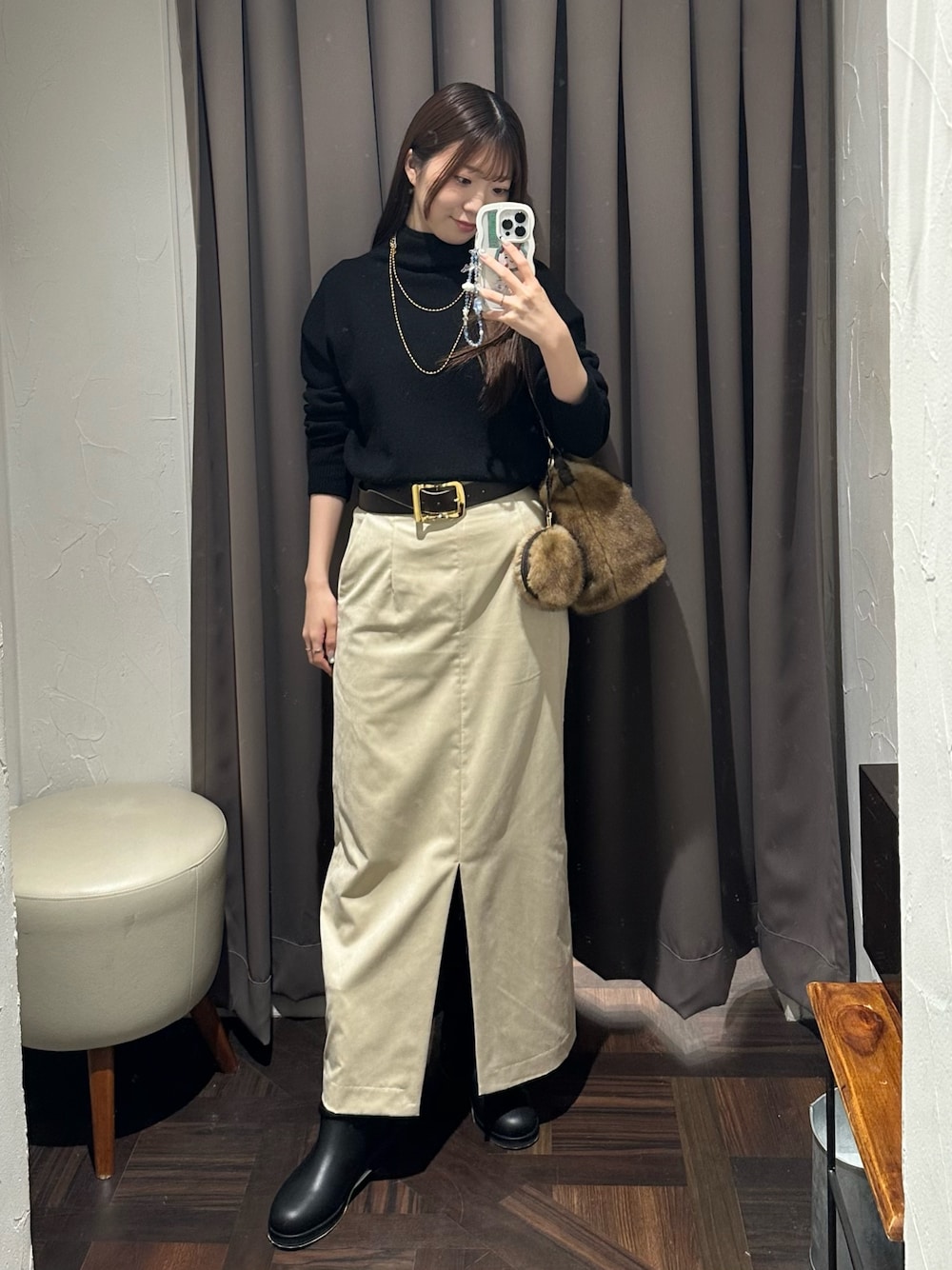 ブラック系のニット/セーター、ベージュ系のスカート、イエロー系のハンドバッグを着用したレディースの秋コーディネートの1枚目の写真