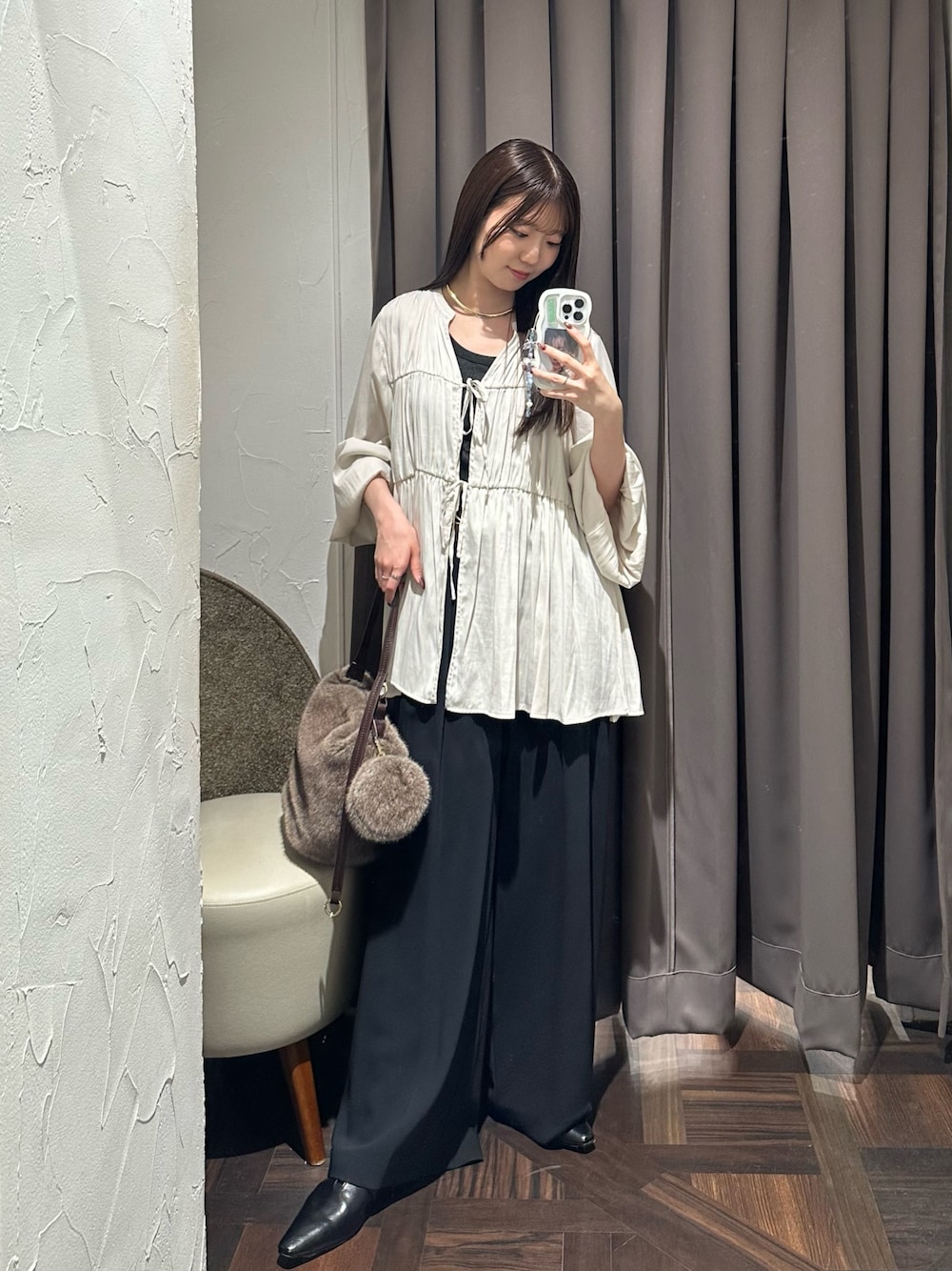 ホワイト系のシャツ/ブラウス、ブラック系のスラックス、ブラウン系のハンドバッグを着用したレディースの秋コーディネートの1枚目の写真