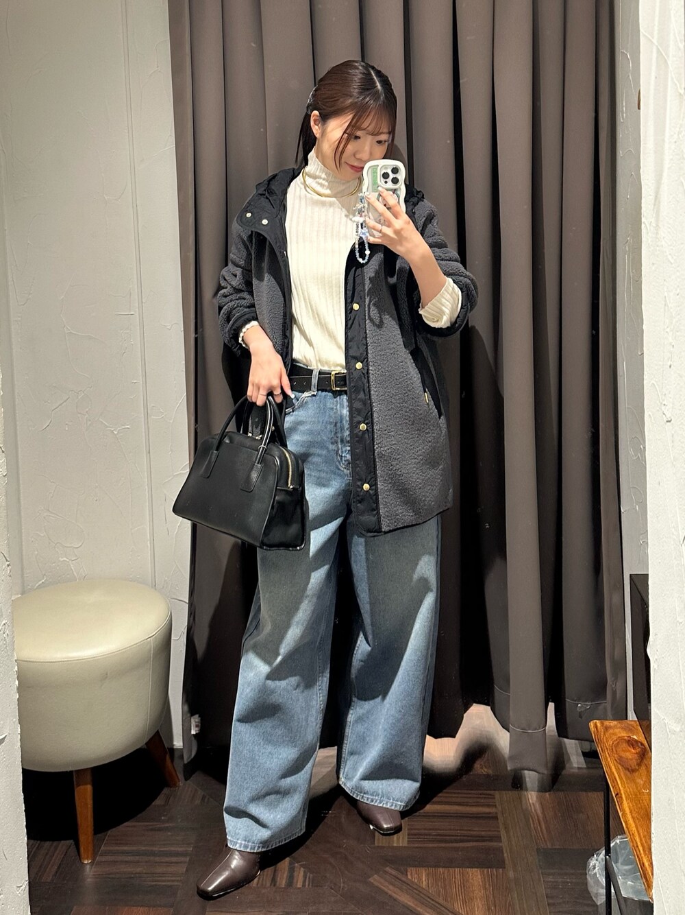 ブルー系のデニムパンツ、グレー系のその他アウター、ブラック系のボストンバッグを着用したレディースの秋コーディネートの1枚目の写真