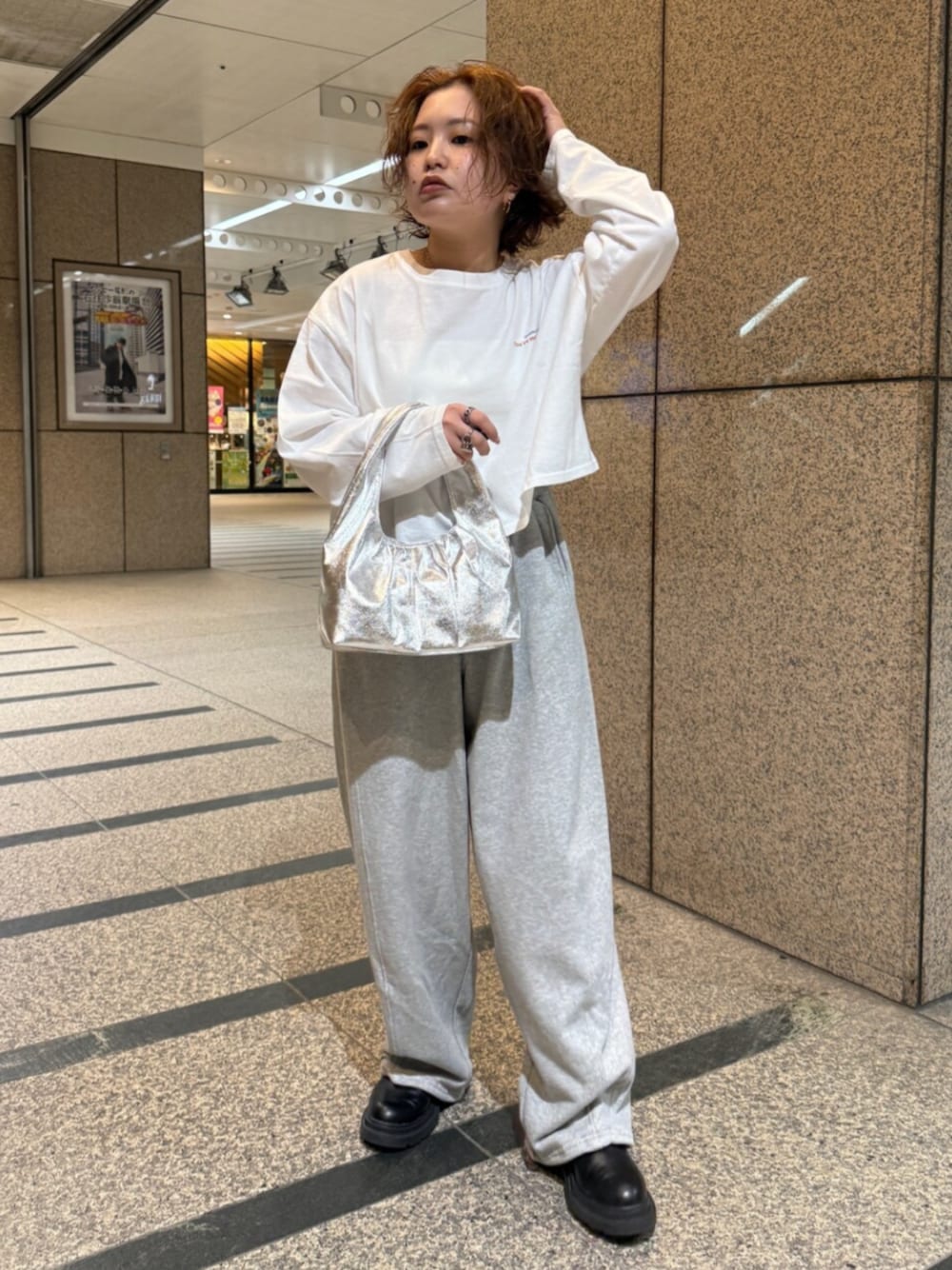 ホワイト系のTシャツ/カットソー、シルバー系のハンドバッグ、グレー系のスウェットパンツを着用したレディースの冬コーディネートの1枚目の写真