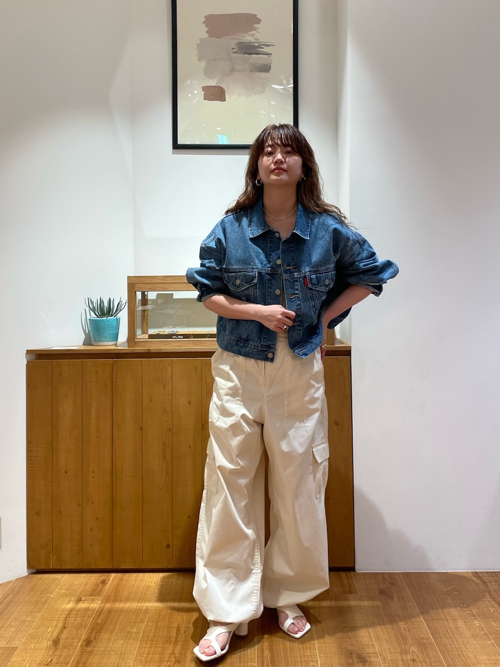 ブルー系のデニムジャケット、ホワイト系のつなぎ/オールインワン、ホワイト系のサンダルを着用したレディースの春コーディネートの1枚目の写真