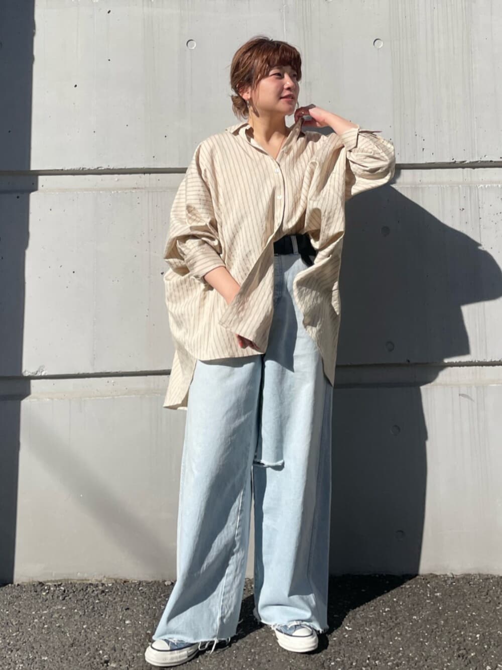 ブルー系のデニムパンツ、ブルー系のスニーカー、イエロー系のシャツ/ブラウスを着用したレディースの春コーディネートの1枚目の写真