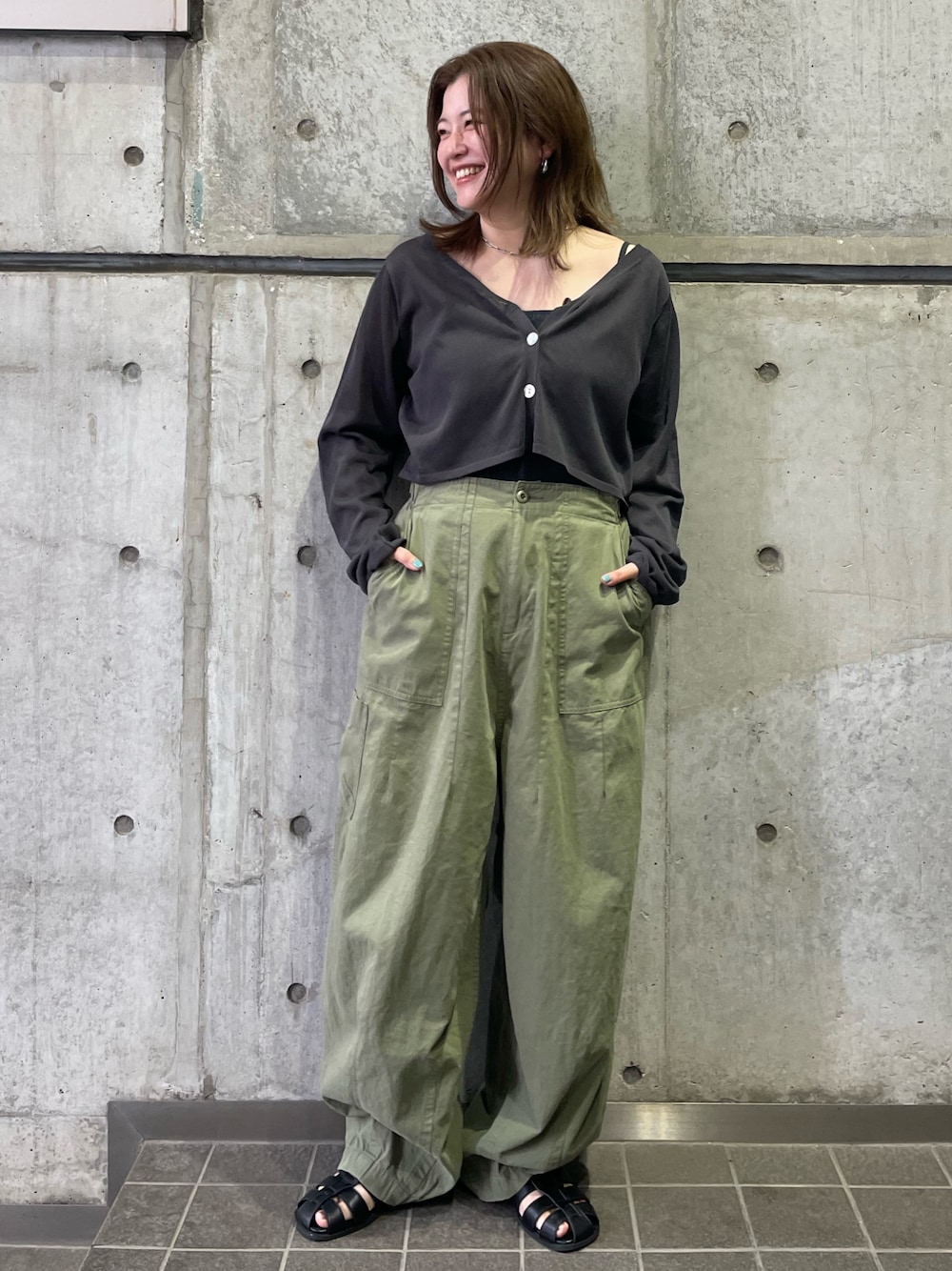 グリーン系のその他パンツ、グレー系のカーディガン/ボレロ、ブラック系のサンダルを着用したレディースの春コーディネートの1枚目の写真