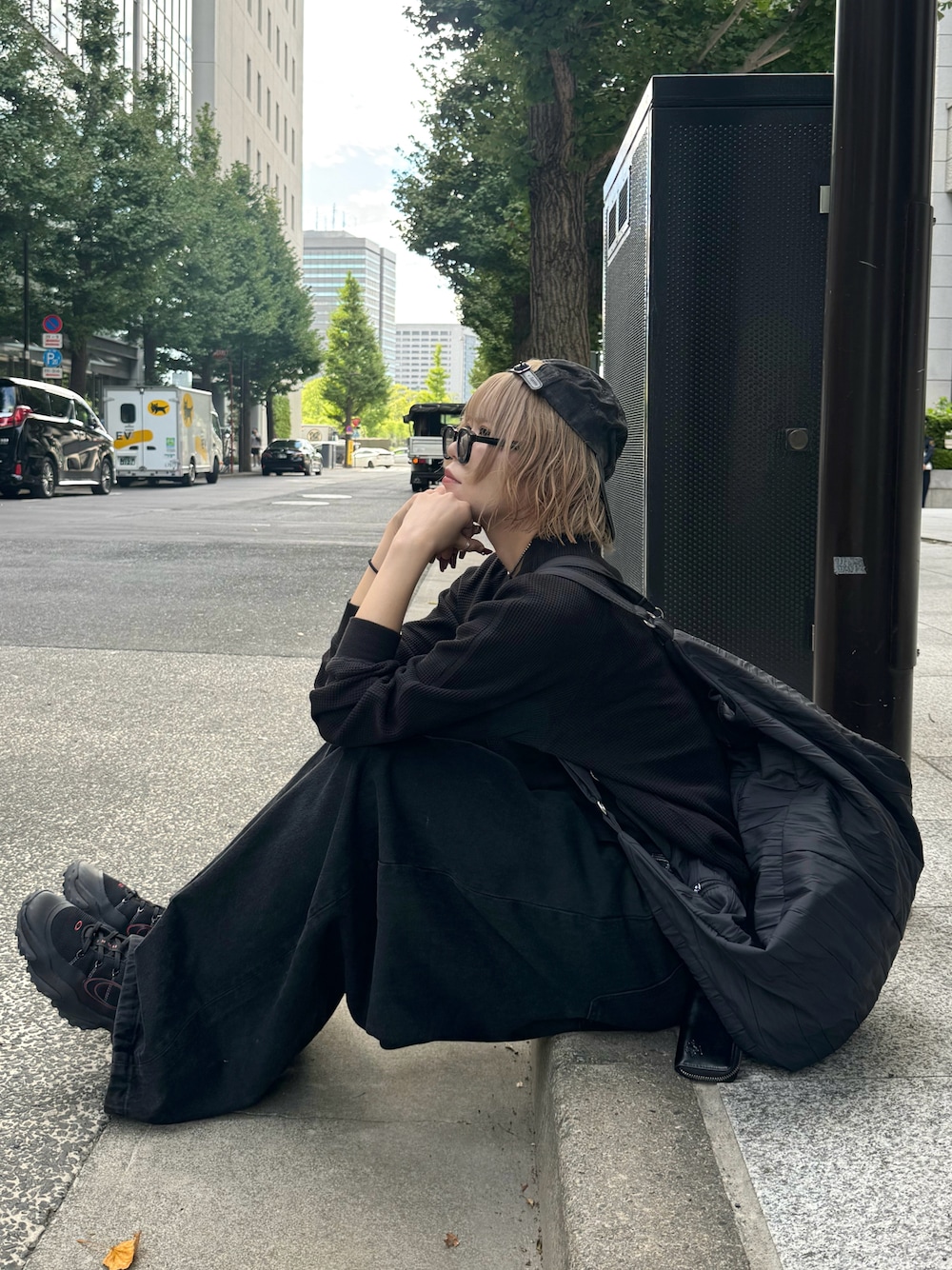 ブラック系のデニムパンツ、ブラック系のスニーカー、ブラック系のショルダーバッグを着用したレディースの冬コーディネートの1枚目の写真