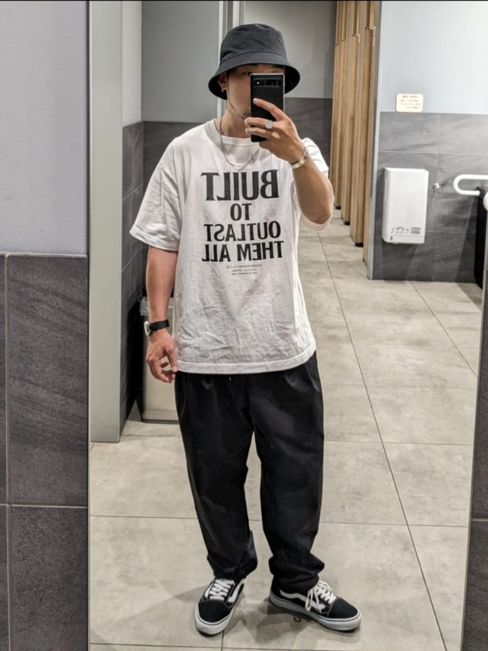 ホワイト系のTシャツ/カットソー、ブラック系のその他パンツ、ブラック系のスニーカーを着用したメンズの春コーディネートの1枚目の写真