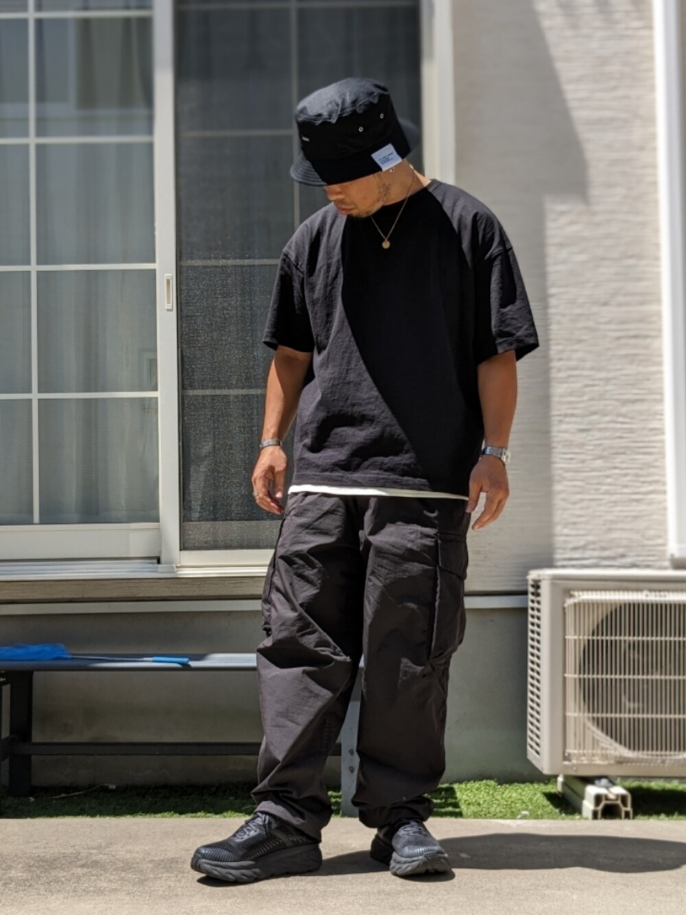 ブラック系のTシャツ/カットソー、ブラック系のカーゴパンツ、ブラック系のスニーカーを着用したメンズの夏コーディネートの1枚目の写真