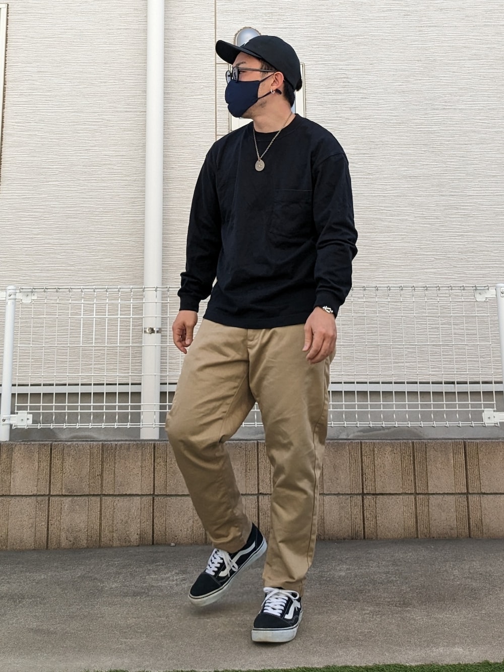 ブラック系のTシャツ/カットソー、ベージュ系のチノパンツ、ブラック系のスニーカーを着用したメンズの春コーディネートの1枚目の写真
