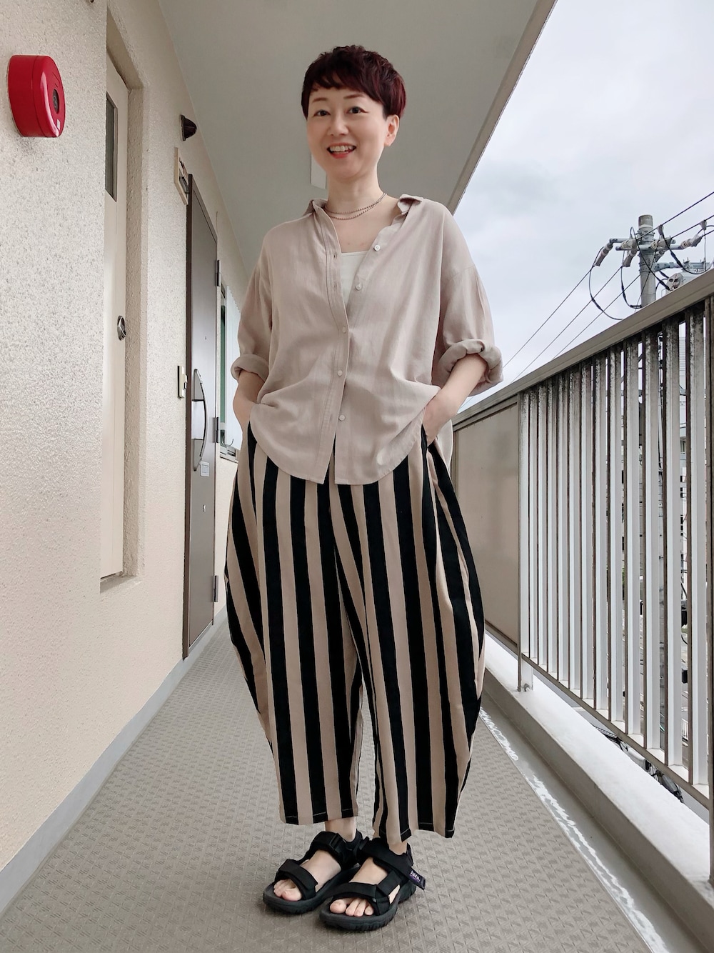 ホワイト系のキャミソール、ブラック系のその他パンツ、ブラック系のサンダルを着用したレディースの春コーディネートの1枚目の写真