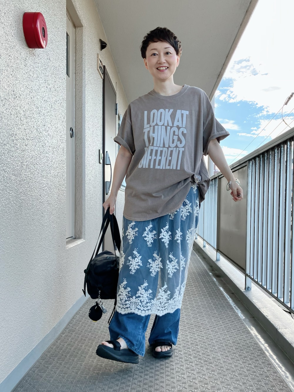 ベージュ系のTシャツ/カットソー、ホワイト系のスカート、ブルー系のデニムパンツを着用したレディースの夏コーディネートの1枚目の写真