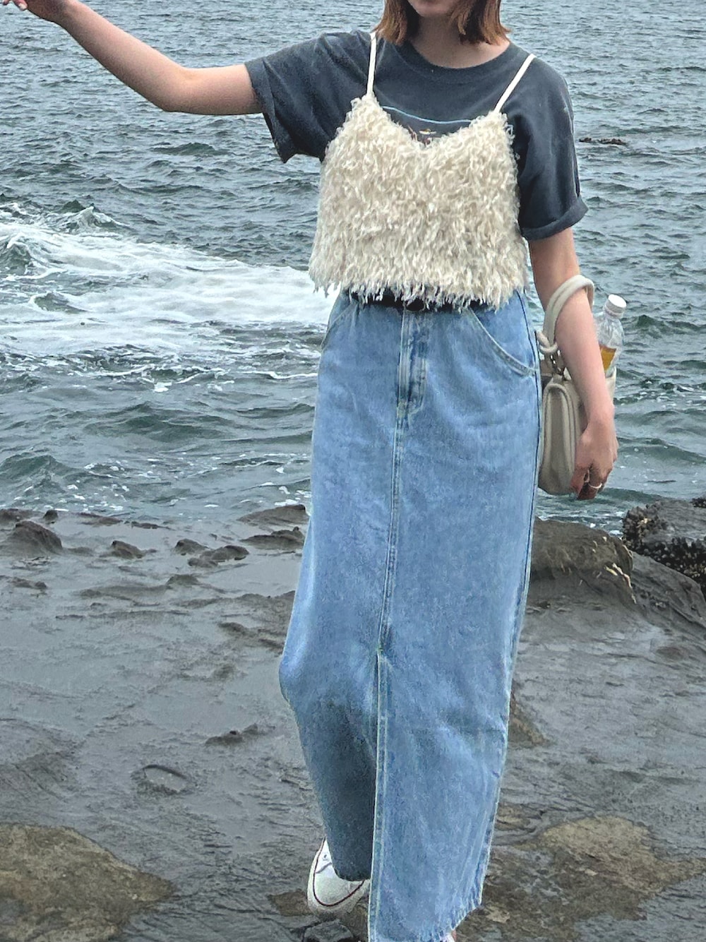 ホワイト系のシャツ/ブラウス、ホワイト系のハンドバッグ、ブルー系のデニムスカートを着用したレディースの春コーディネートの1枚目の写真