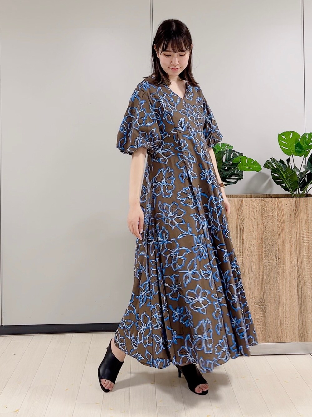 ブラウン系のワンピース、ブラック系のサンダルを着用したレディースの春コーディネートの1枚目の写真