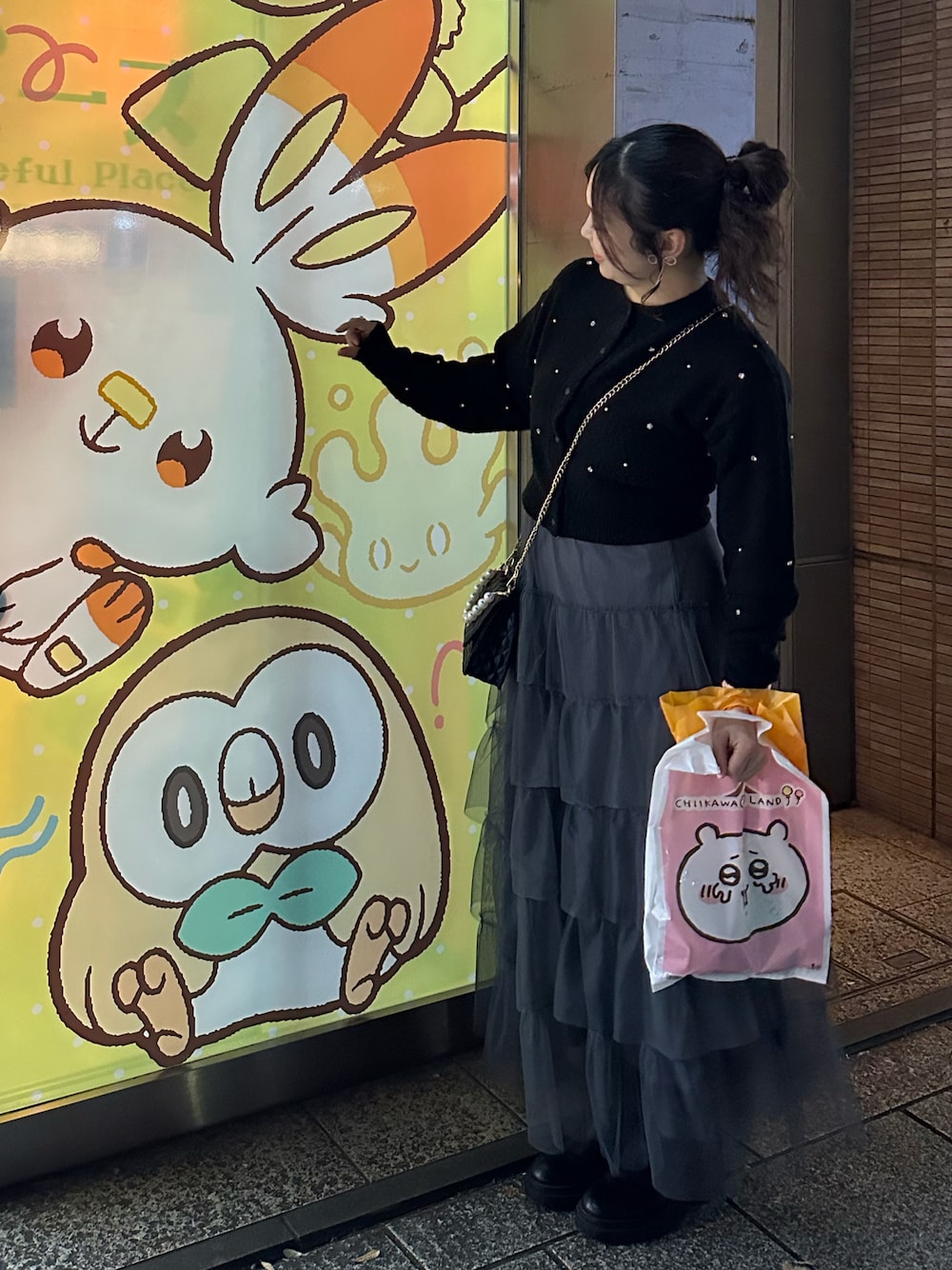 グレー系のスカート、ブラック系のニット/セーターを着用したレディースの秋コーディネートの1枚目の写真