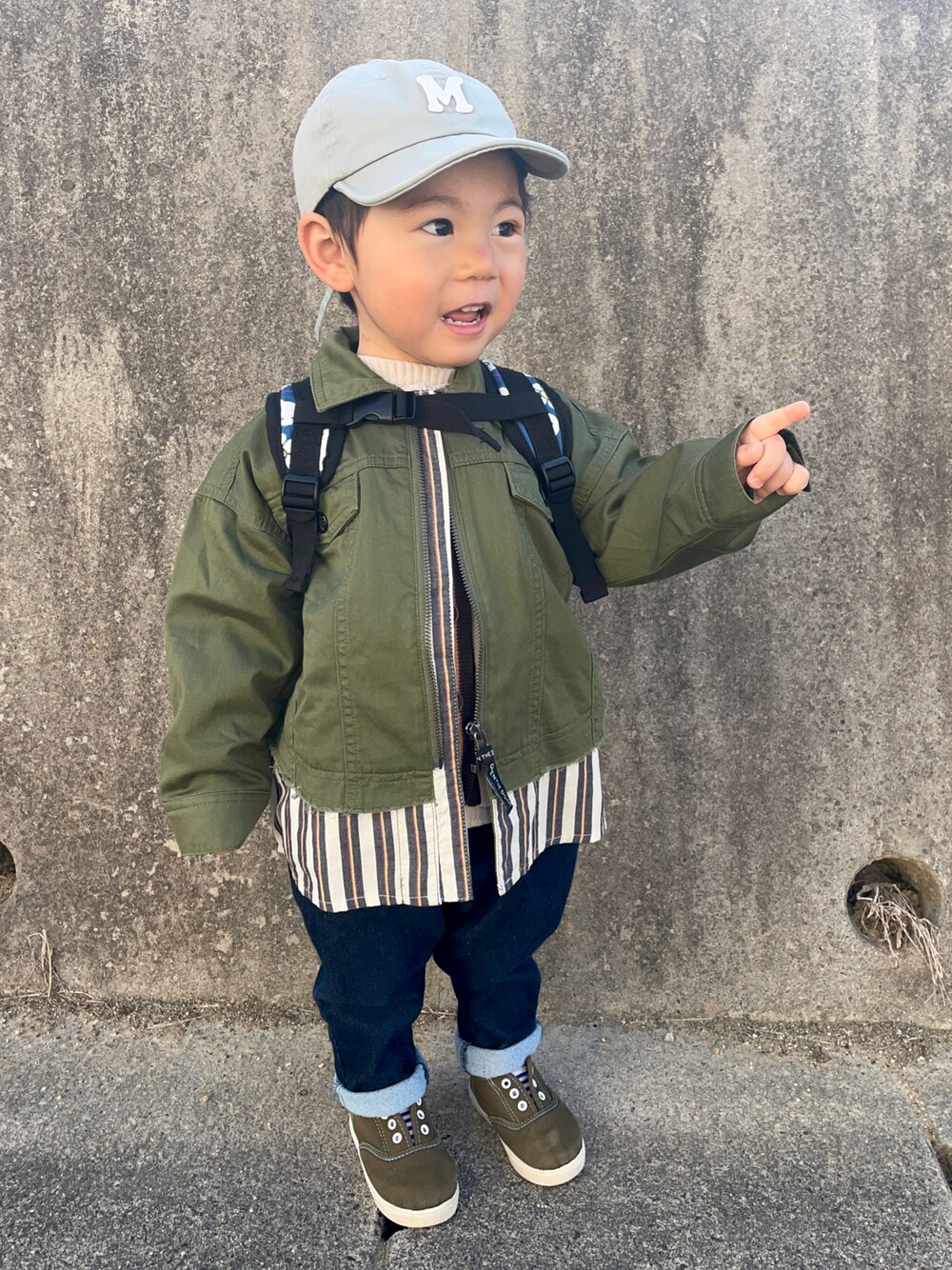 ベージュ系のベスト、ホワイト系のTシャツ/カットソー、グリーン系のデニムジャケットを着用したキッズの春コーディネートの1枚目の写真