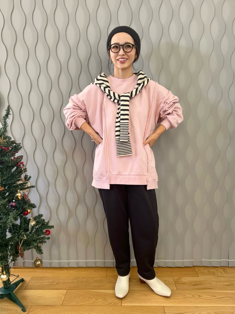 ホワイト系のニット/セーター、ピンク系のスウェット、ブラック系のパンツを着用したレディースの冬コーディネートの1枚目の写真