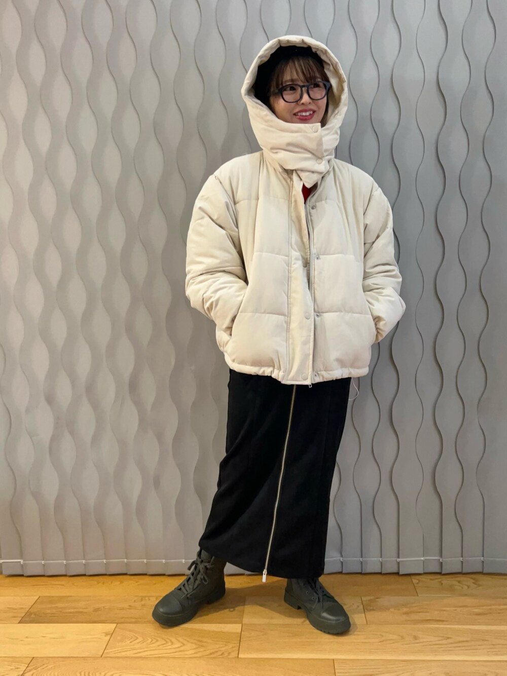 ホワイト系のダウンジャケット/コート、ブラック系のスカート、グリーン系のスニーカーを着用したレディースの冬コーディネートの1枚目の写真