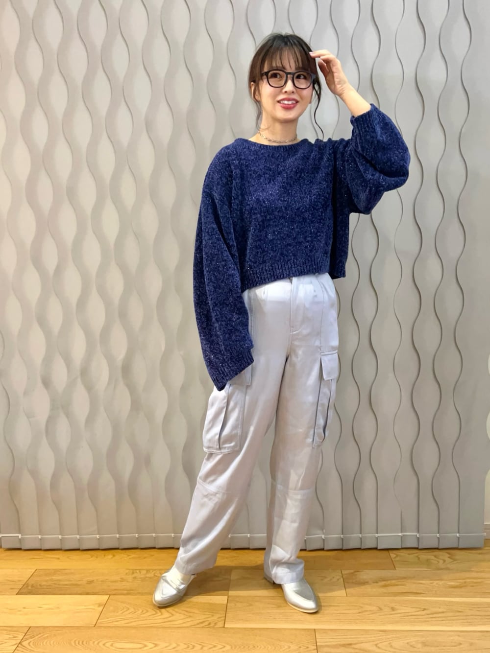 ブルー系のニット/セーター、ブルー系のカーゴパンツ、シルバー系のスリッポンを着用したレディースの冬コーディネートの1枚目の写真