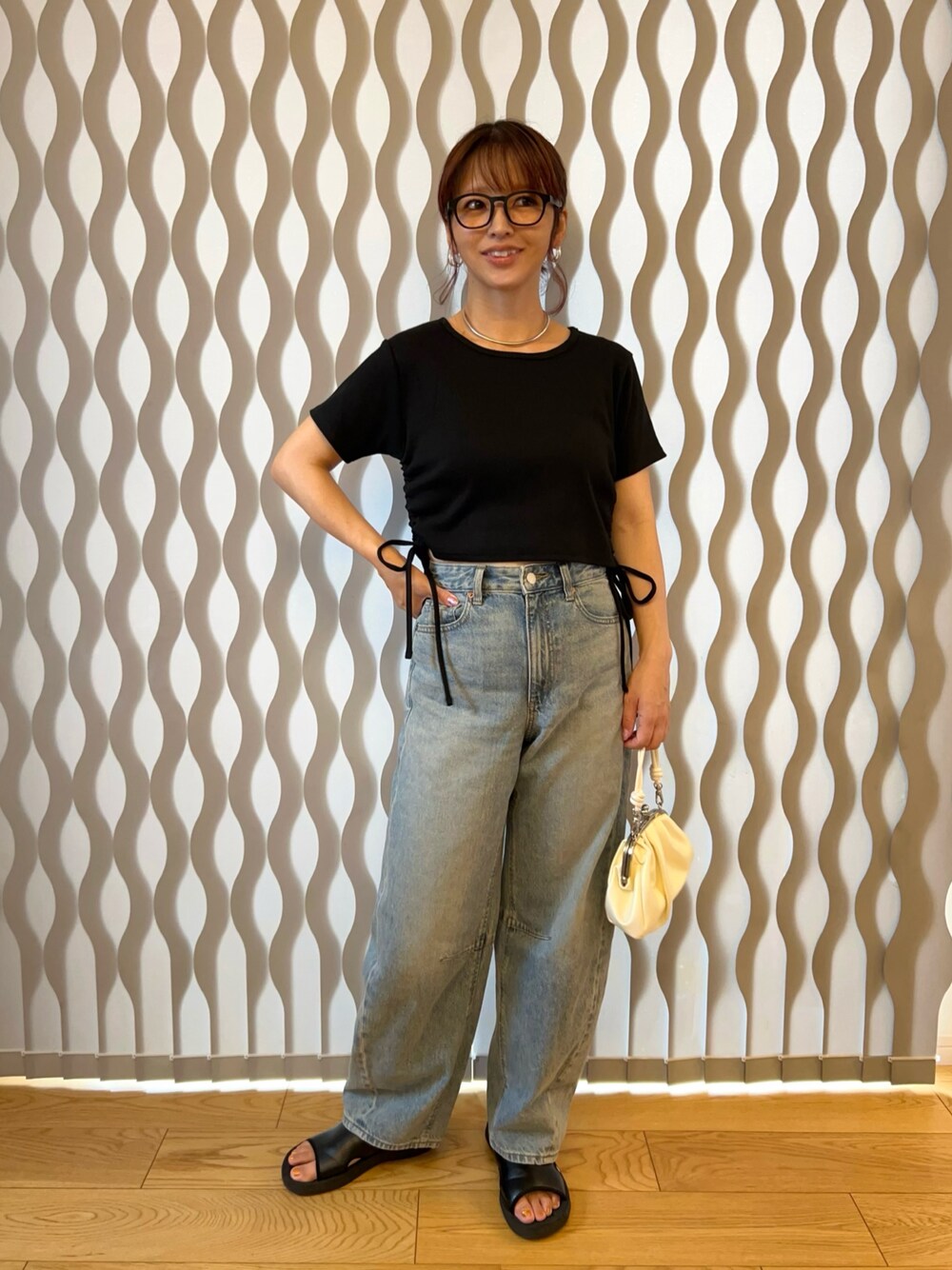 ブラック系のTシャツ/カットソー、ブルー系のデニムパンツ、ホワイト系のハンドバッグを着用したレディースの夏コーディネートの1枚目の写真