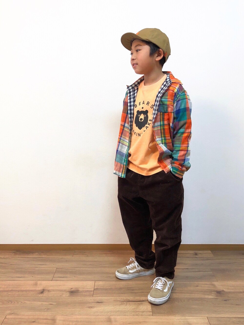オレンジ系のシャツ/ブラウス、ブラウン系のその他パンツ、ベージュ系のスニーカーを着用したキッズの冬コーディネートの1枚目の写真