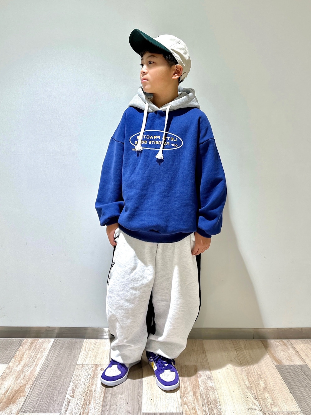 ブルー系のパーカー、その他のスウェットパンツ、パープル系のスニーカーを着用したキッズの冬コーディネートの1枚目の写真