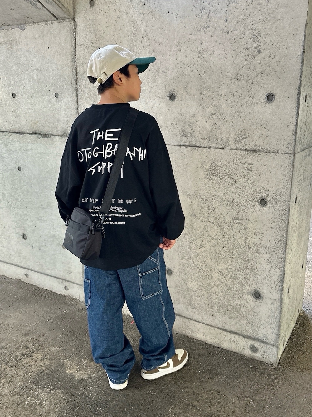 ブラック系のTシャツ/カットソー、ブルー系のその他パンツ、ブラック系のショルダーバッグを着用したキッズの秋コーディネートの1枚目の写真