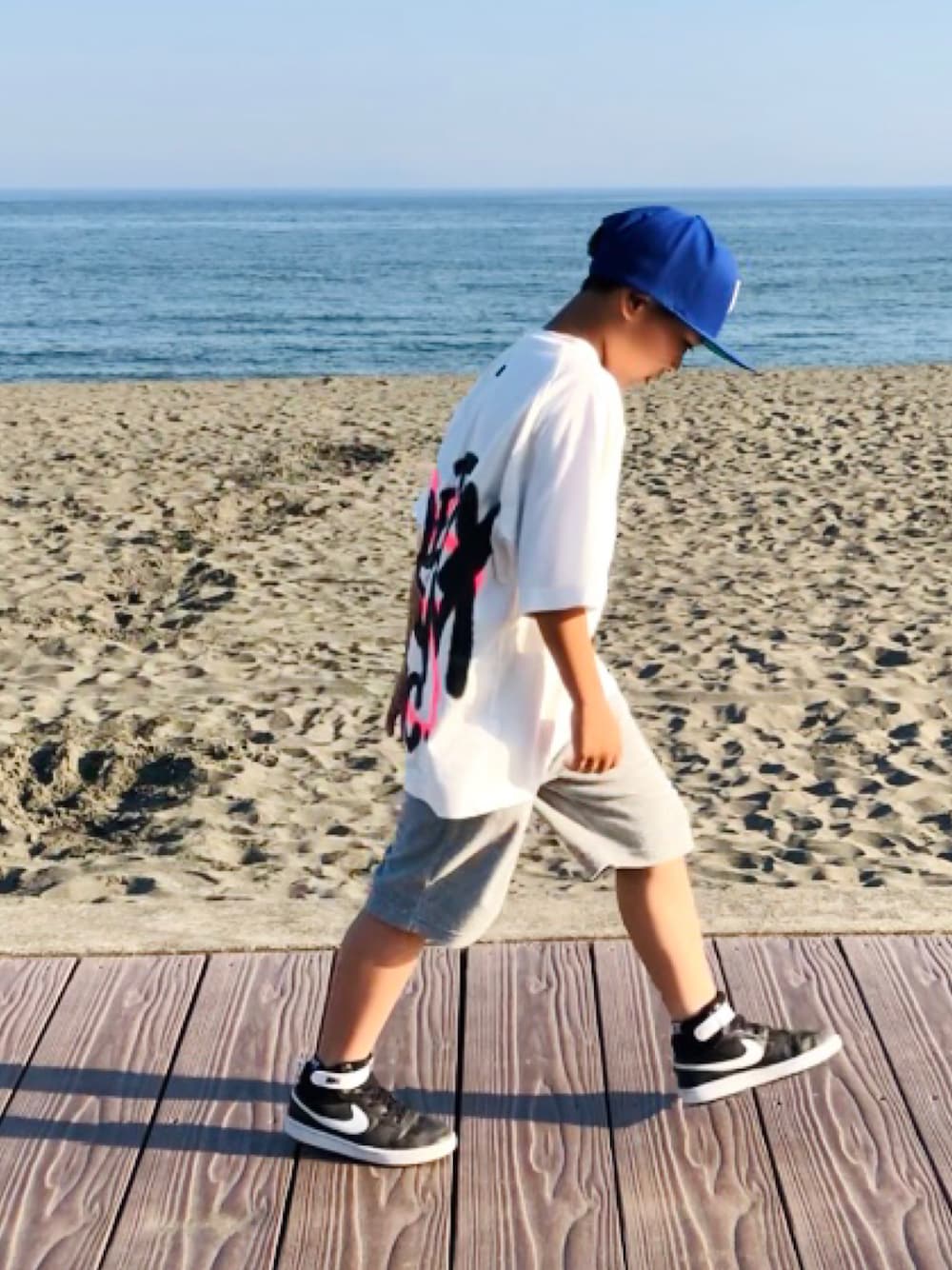 ホワイト系のTシャツ/カットソー、グレー系のその他パンツ、ブラック系のスニーカーを着用したキッズの夏コーディネートの1枚目の写真