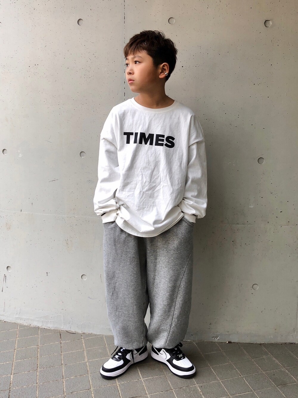 ホワイト系のTシャツ/カットソー、グレー系のスウェットパンツ、ホワイト系のスニーカーを着用したキッズの春コーディネートの1枚目の写真