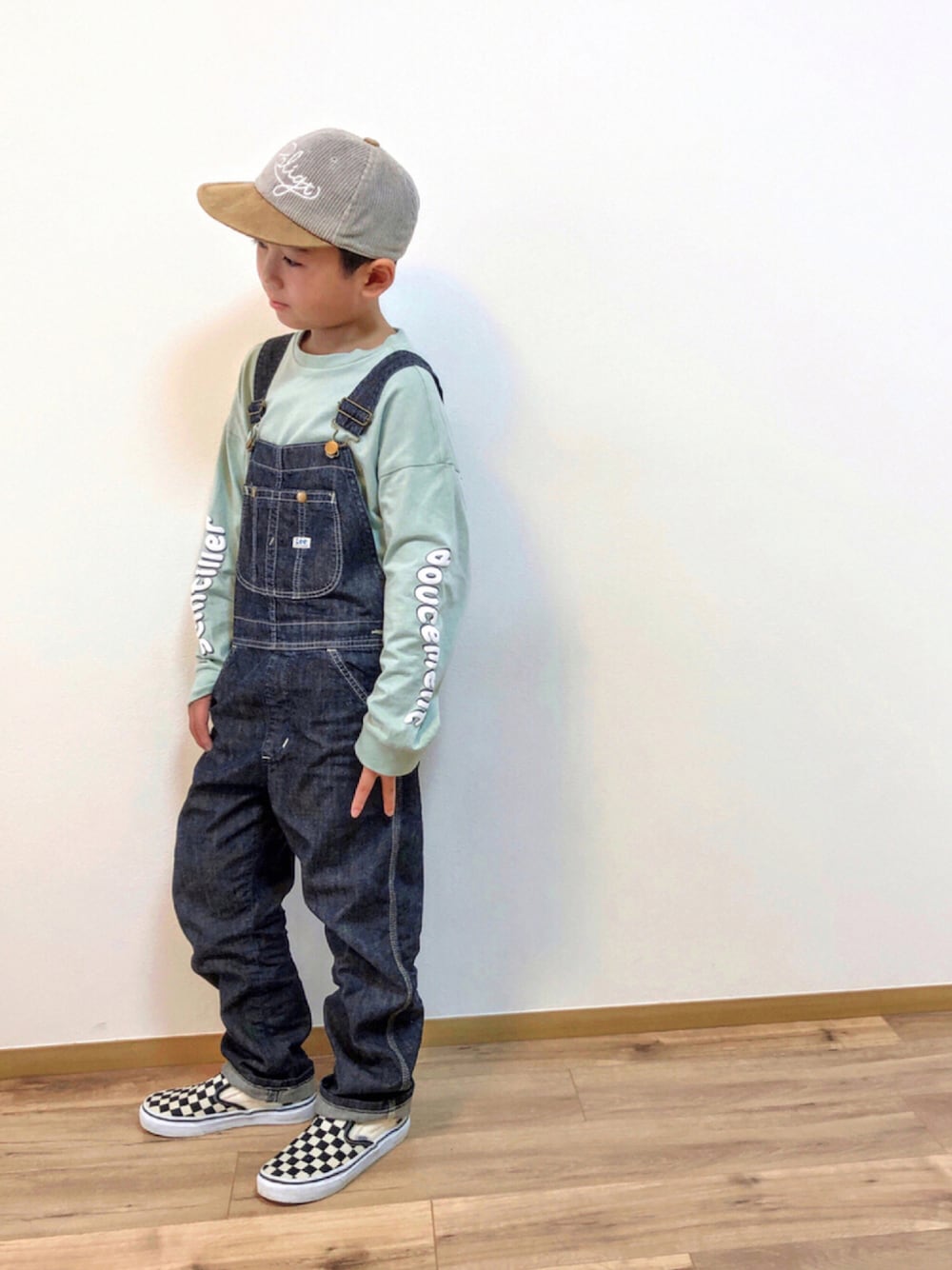 グリーン系のTシャツ/カットソー、ブルー系のサロペット/オーバーオール、ブラック系のスリッポンを着用したキッズの秋コーディネートの1枚目の写真