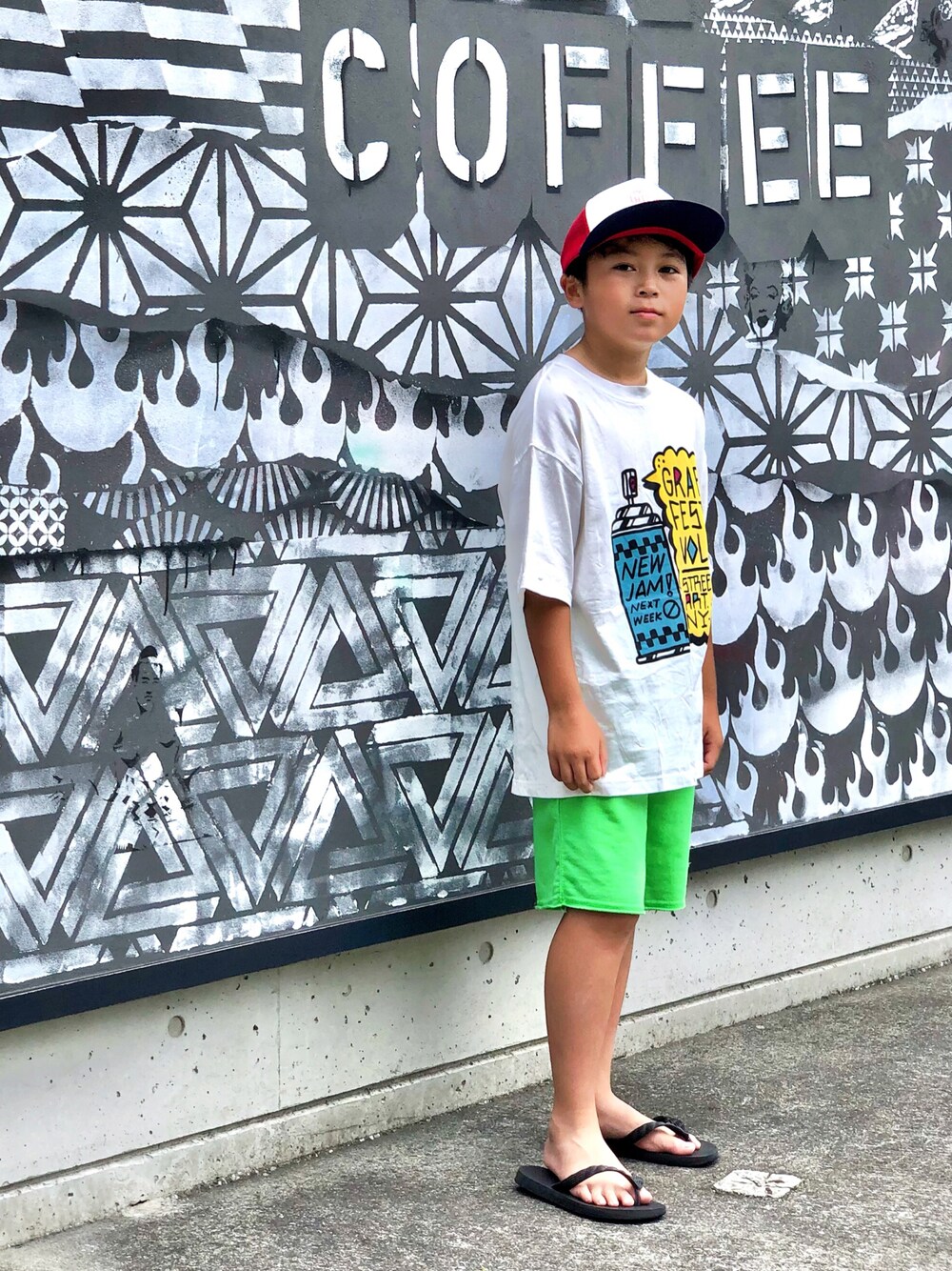 ホワイト系のTシャツ/カットソー、グリーン系のパンツ、ブラック系のサンダルを着用したキッズの夏コーディネートの1枚目の写真