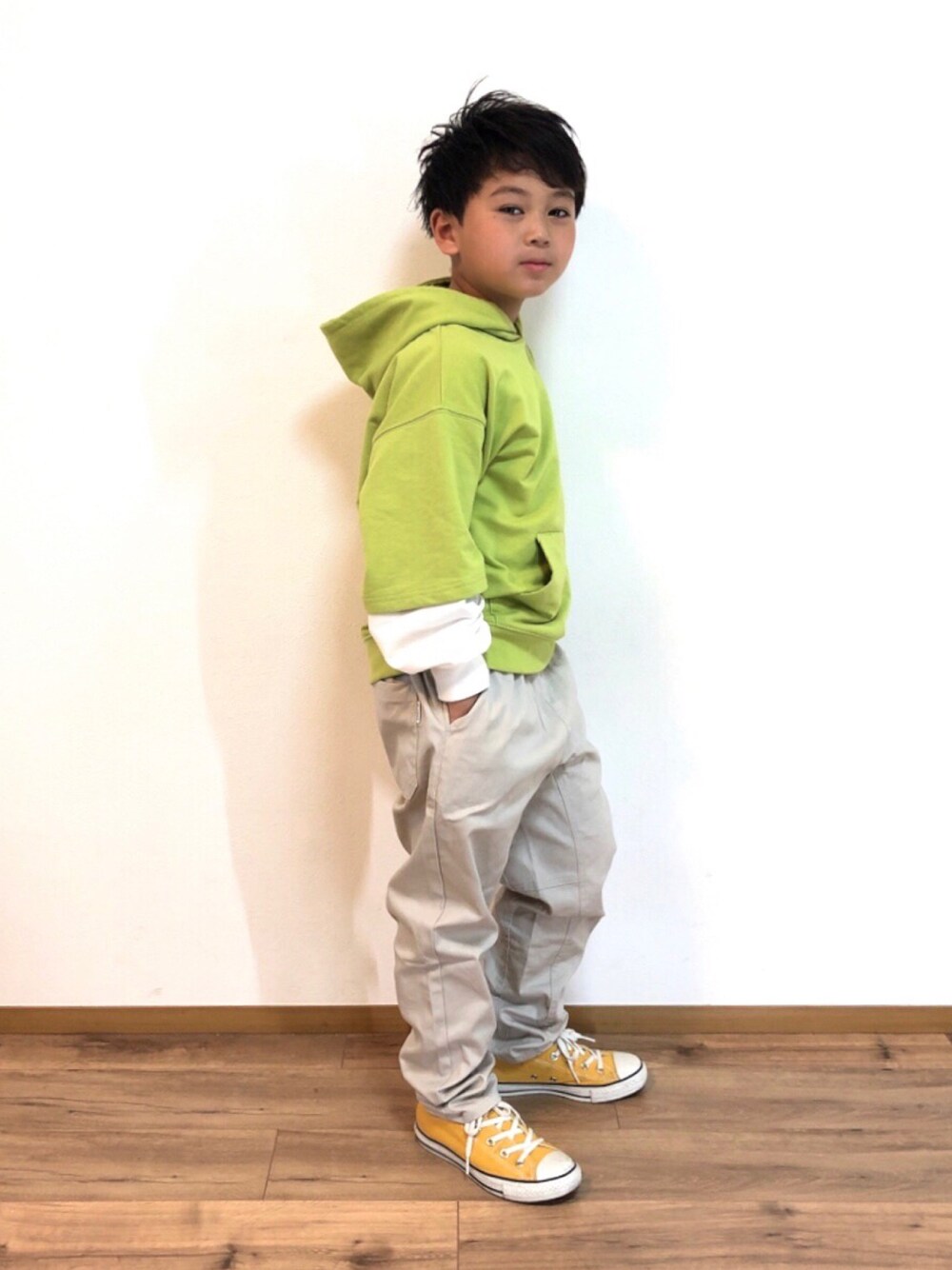 グリーン系のパーカー、ベージュ系のその他パンツ、イエロー系のスニーカーを着用したキッズの春コーディネートの1枚目の写真