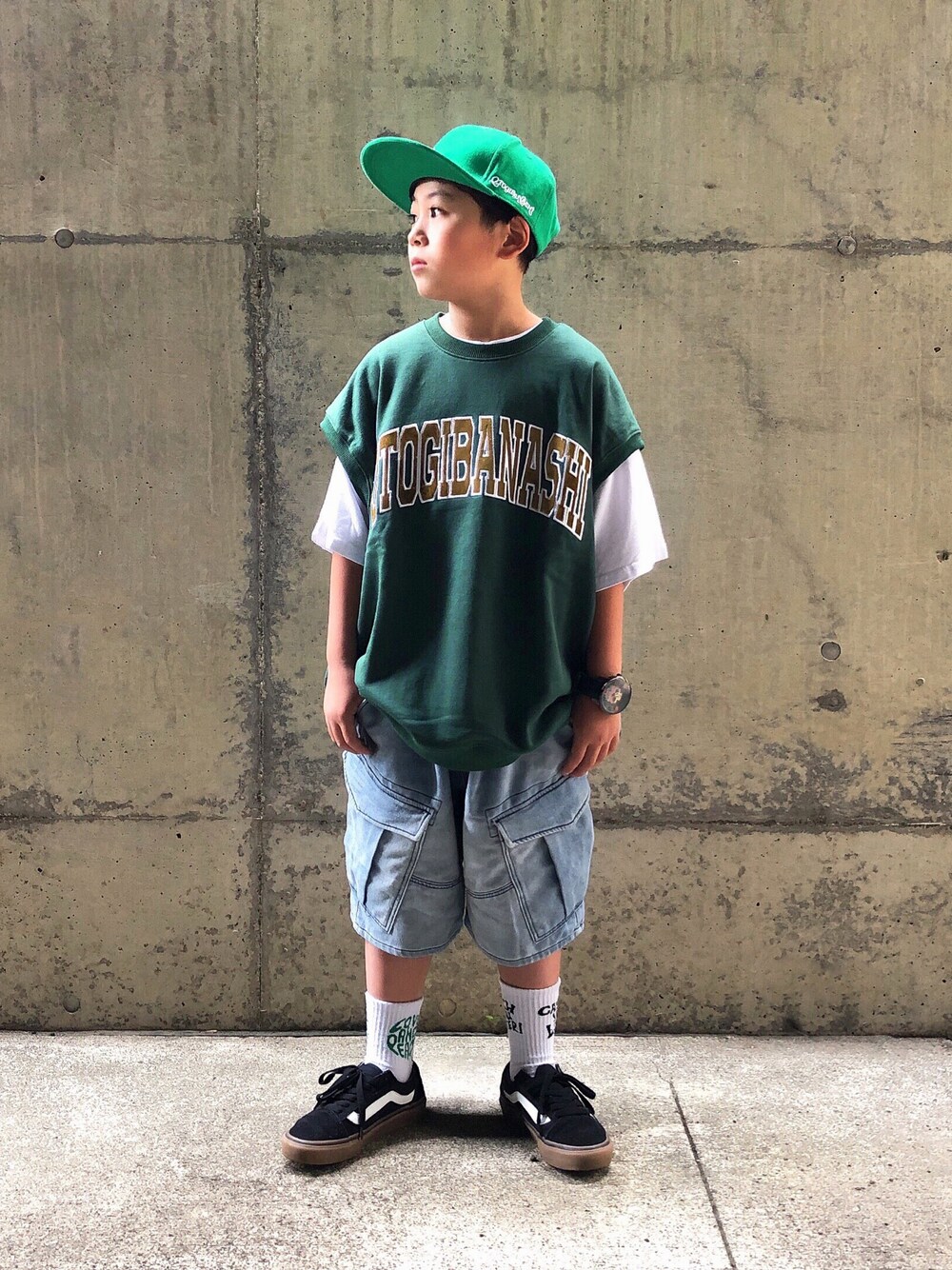グリーン系のベスト、ホワイト系のTシャツ/カットソー、ブルー系のスウェットパンツを着用したキッズの夏コーディネートの1枚目の写真