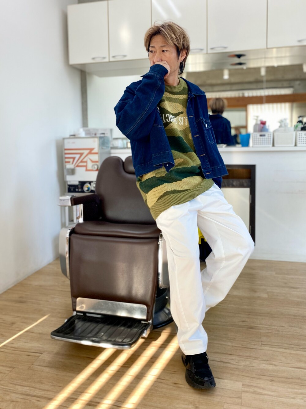 ホワイト系のチノパンツ、グリーン系のニット/セーター、ブルー系のデニムジャケットを着用したメンズの冬コーディネートの1枚目の写真