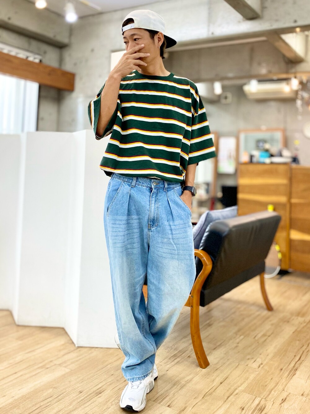 グリーン系のTシャツ/カットソー、ブルー系のデニムパンツ、ホワイト系のキャップを着用したメンズの秋コーディネートの1枚目の写真