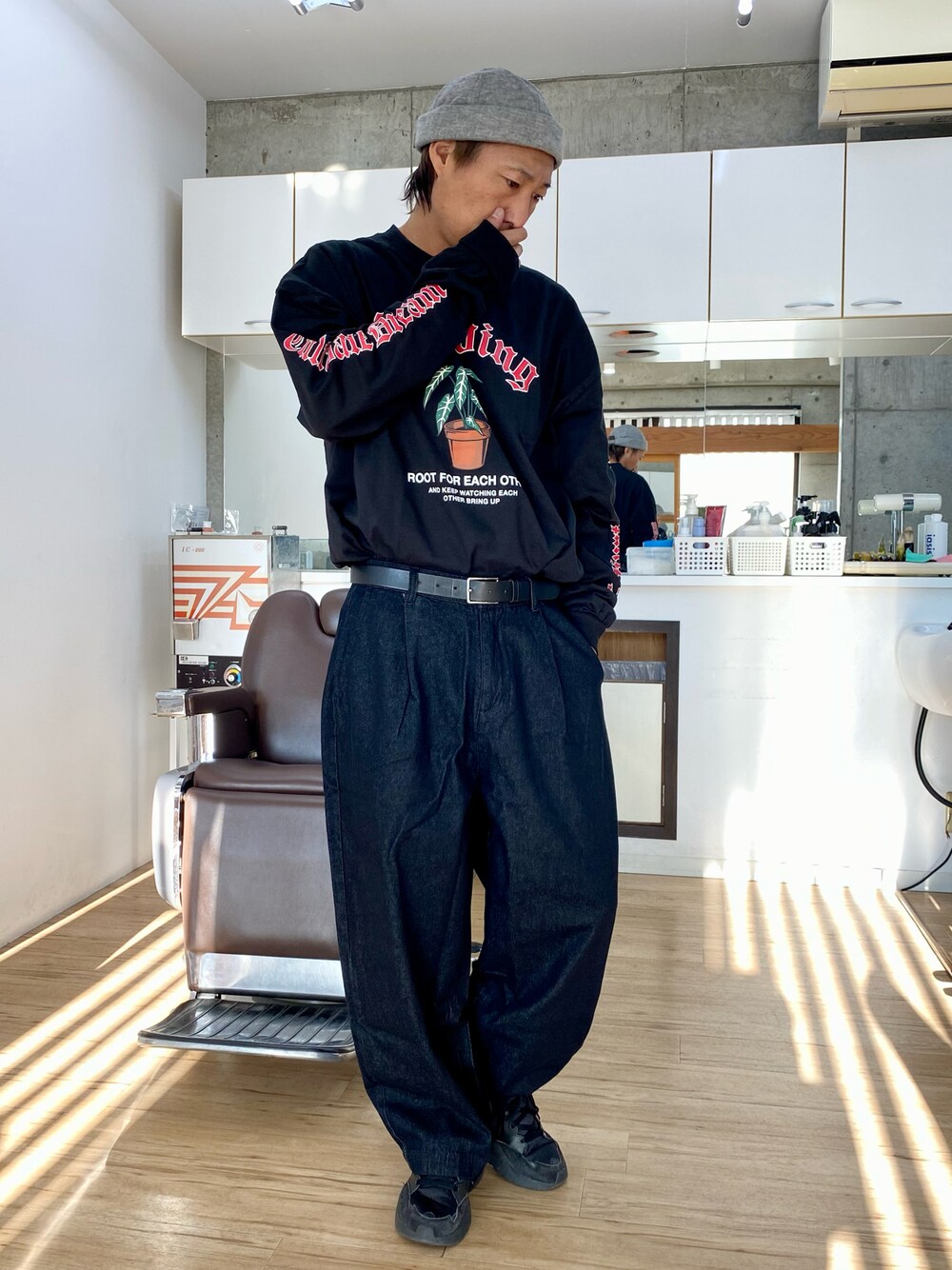 ブラック系のデニムパンツ、ブラック系のスニーカー、ブラック系のTシャツ/カットソーを着用したメンズの冬コーディネートの1枚目の写真