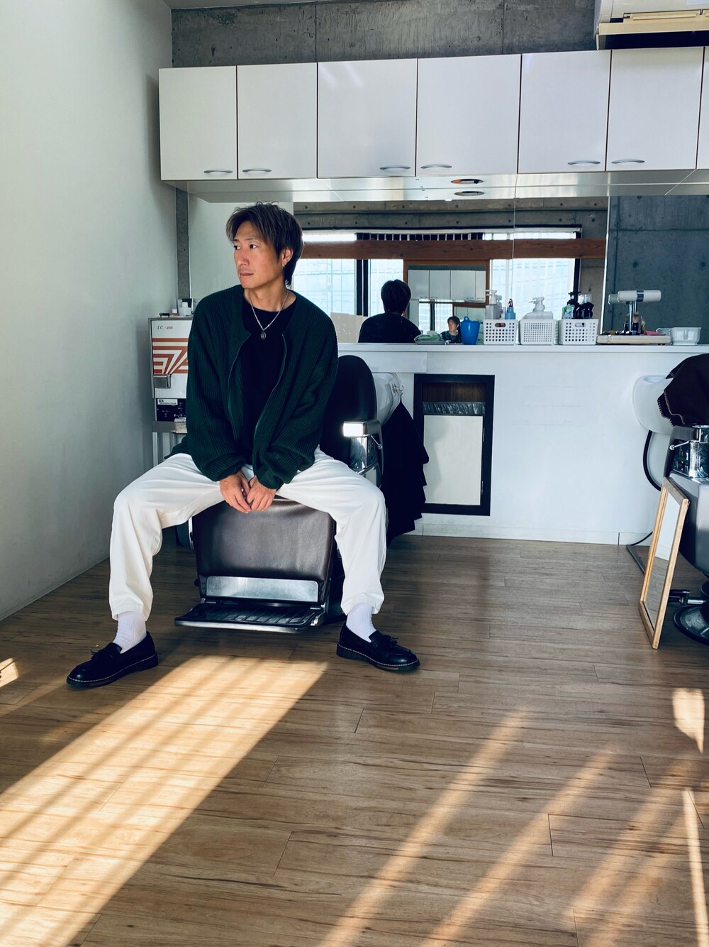 ホワイト系のチノパンツ、グリーン系のカーディガン/ボレロを着用したメンズの秋コーディネートの1枚目の写真