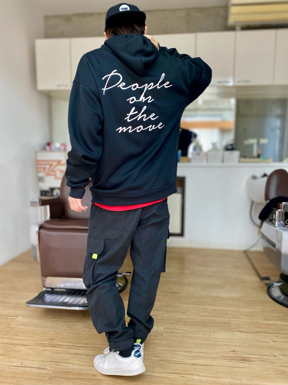 ブラック系のカーゴパンツ、ホワイト系のスニーカー、ブラック系のパーカーを着用したメンズの冬コーディネートの1枚目の写真