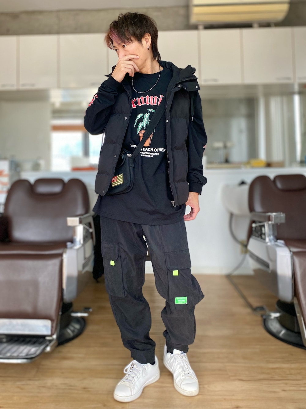 ブラック系のカーゴパンツ、ホワイト系のスニーカー、ブラック系のTシャツ/カットソーを着用したメンズの冬コーディネートの1枚目の写真